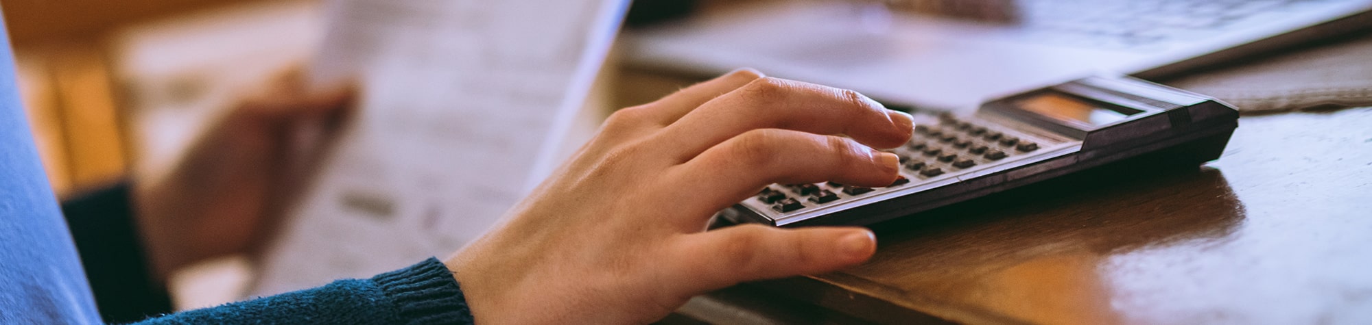 Parent crunching numbers in a calculator to budget for college