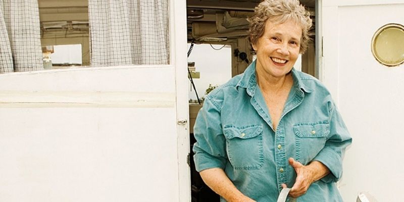 Older woman in retirement standing in front of an open front door