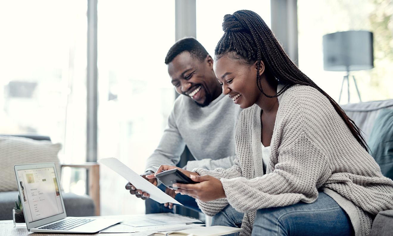 An african american couple sitting in front of a computer discussing finances